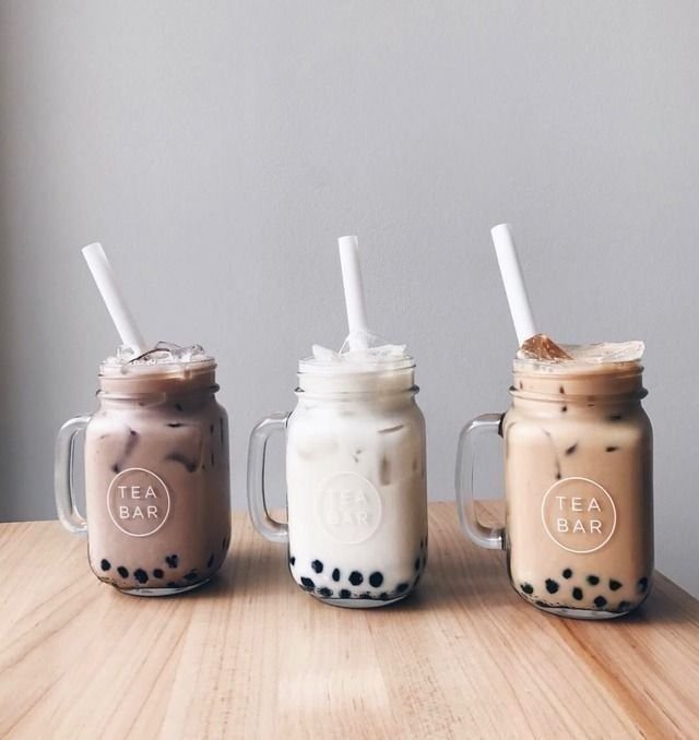 Three bubble tea cups: milk tea, taro and mango